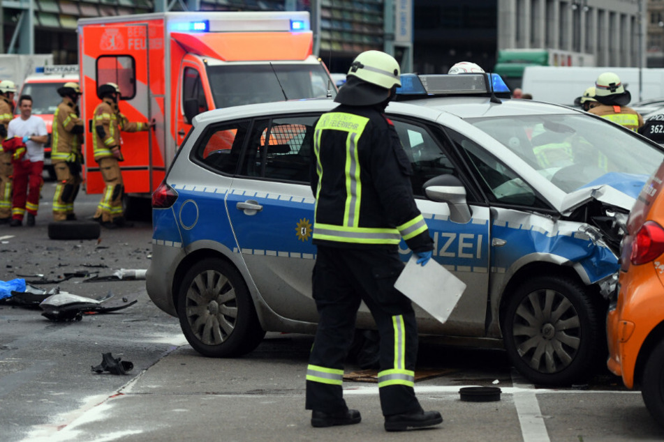 Ein Feuerwehrmann betrachtet das Unfallauto.