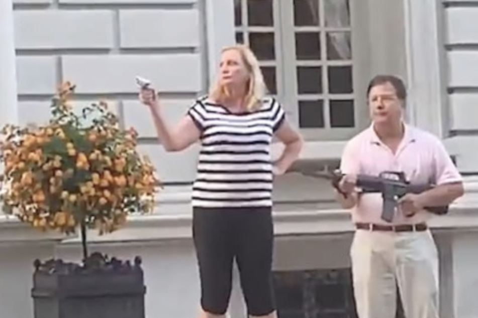 Das Paar bedroht die Protestierenden zunächst von ihrer Terrasse aus mit Waffen.