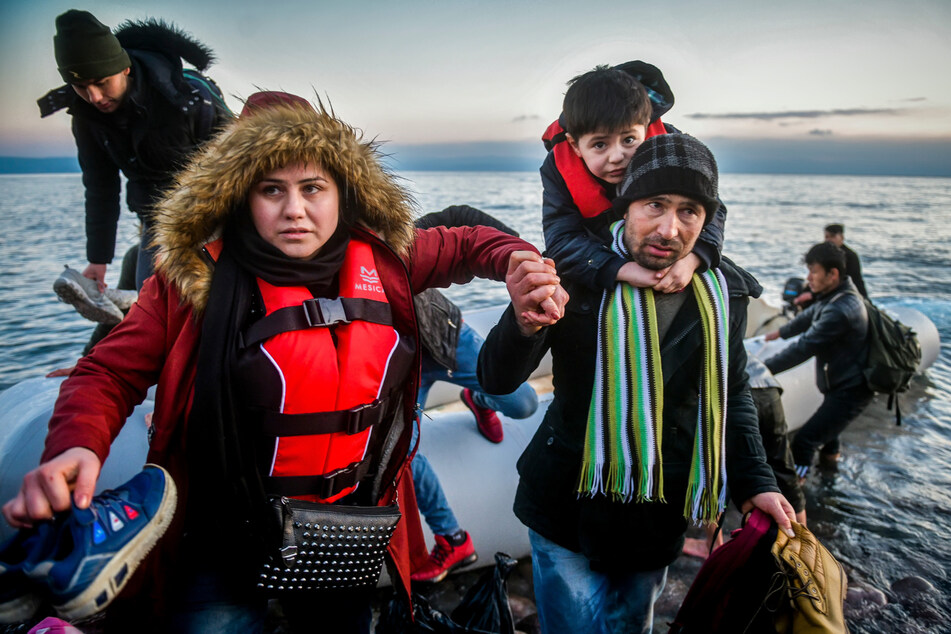 Erschöpfte und verängstigte Flüchtlinge bei ihrer Ankunft am Strand der griechischen Insel Lesbos. Mit einem Schlauchboot sind sie aus der Türkei über das Mittelmeer gekommen.