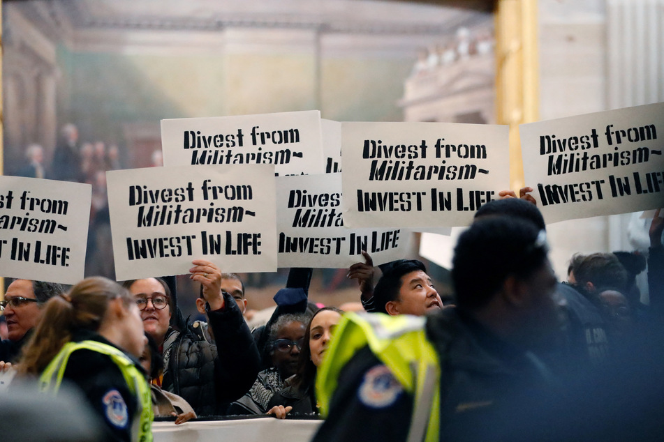 People display signs, chant, and sing during a protest in the US Capitol rotunda to call for a permanent ceasefire in Gaza and oppose a military aid package for Israel.