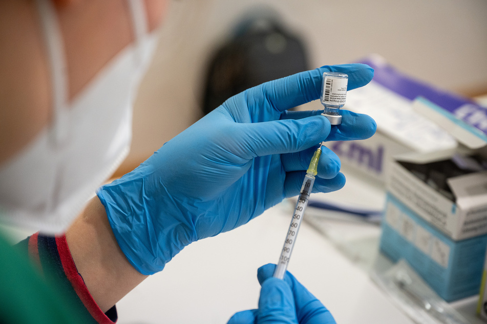 Die Mitarbeiterin eines mobilen Impfteams zieht im Alten- und Pflegeheim Bürgerheim den Impfstoff von Biontech/Pfizer in eine Spritze auf.