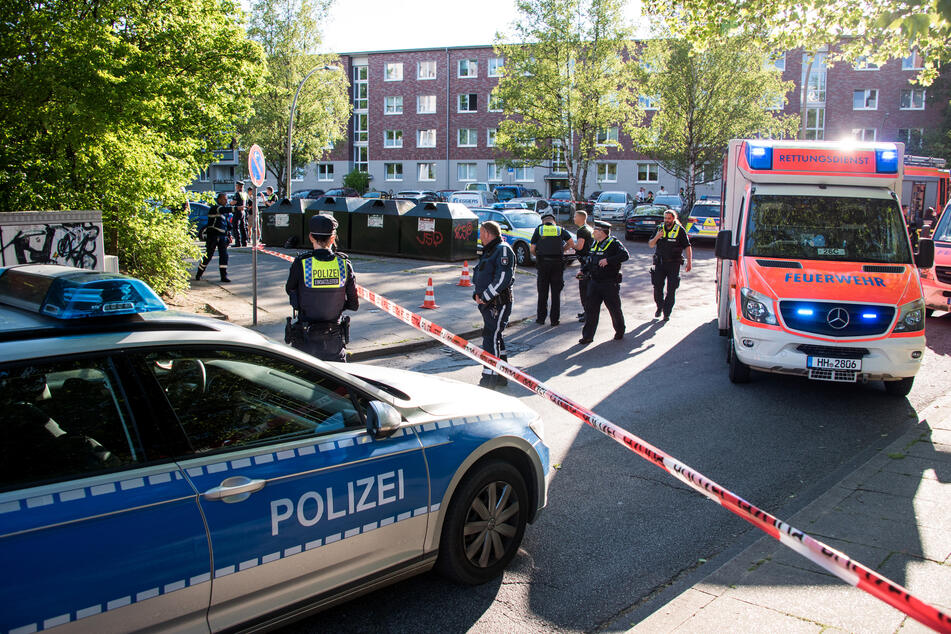 Einsatzkräfte von Polizei und Rettungsdienst stehen am Tatort in Bergedorf.