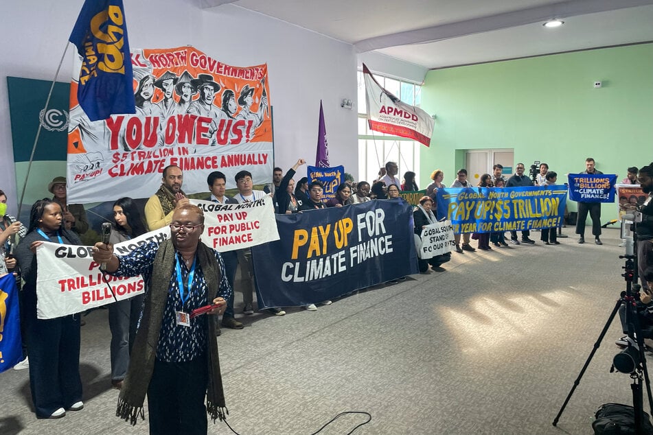 Activists with banners and flags hold a gathering to demand that rich countries help developing nations tackle global warming during the UN Climate Change Conference (COP29) in Baku, Azerbaijan, on November 21, 2024.