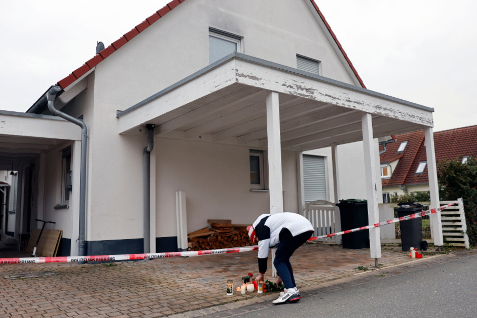 Der Tag nach der schockierenden Tat: Ein Jugendlicher legt eine Kerze und Blumen vor das Haus, in dem die 14-Jährige gewaltsam ums Leben kam.