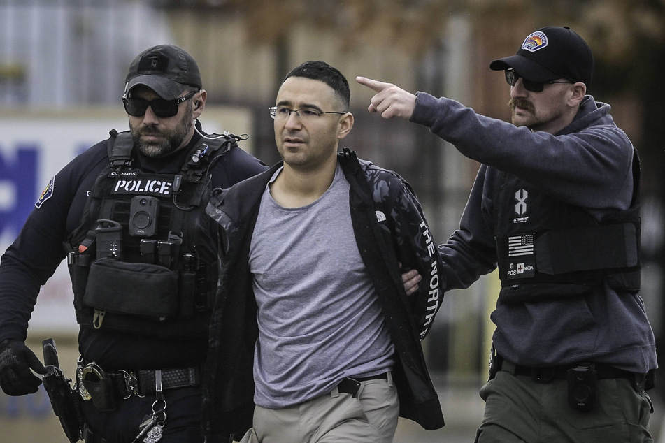Solomon Peña (c.), Republican candidate for New Mexico House District 14, is taken into custody by Albuquerque Police Department officers on Monday afternoon.