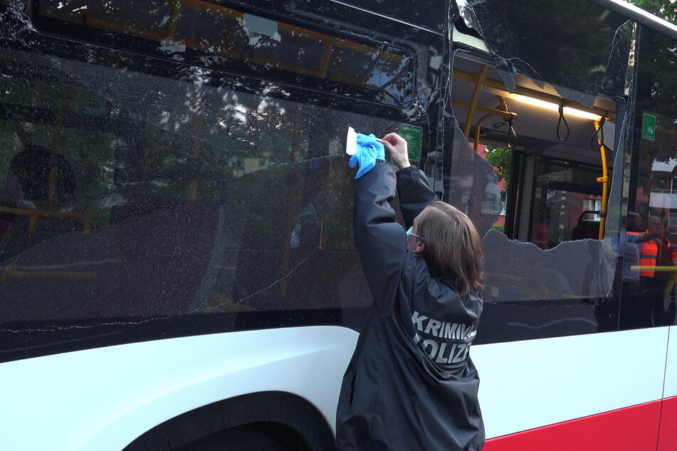 Eine Mitarbeiterin der Kriminalpolizei sichert Spuren an einem der beschossenen Busse.