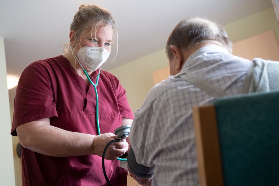 Ruth Schwendtner vom Seniorenhaus Vorbachtal führt bei einem Heimbewohner eine Blutdruckmessung durch.
