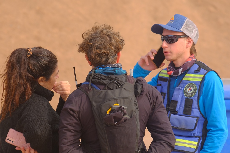 Rettungskräfte beraten sich am Berg, wo die junge Deutsche vermisst wurde.