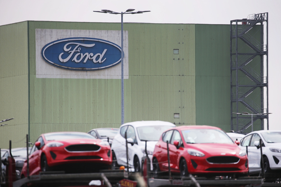 Neu gebaute Autos stehen auf Lastwagen vor dem Ford Werk in Köln.