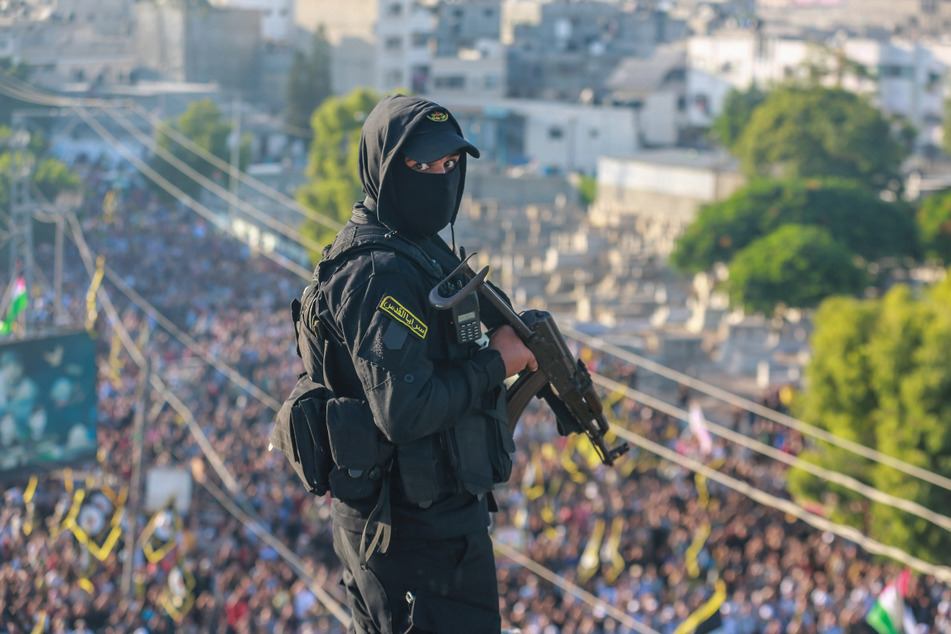 Ein palästinensischer Kämpfer der Bewegung Islamischer Dschihad bewacht eine Versammlung in Palästina.