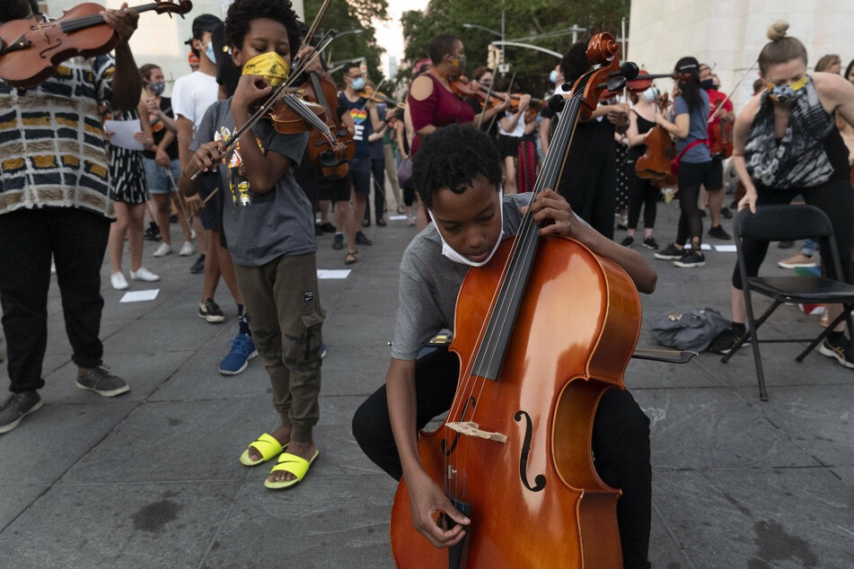 Violinists warm up to play during a Black Lives Matter vigil for Elijah McClain in New York on June 29, 2020.