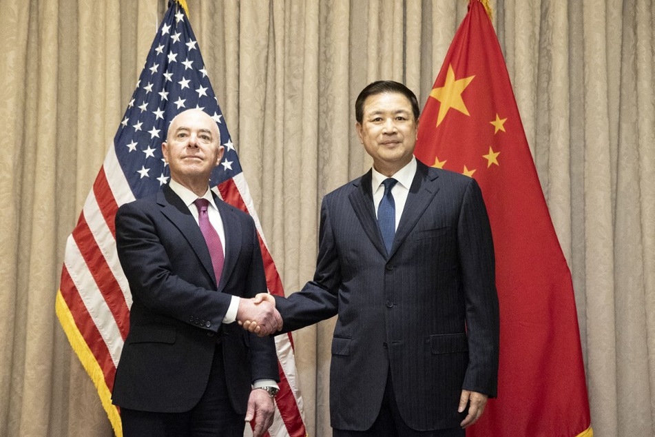 US Minister for Homeland Security, Alejandro Mayorkas shakes hands with Minister of Public Security of China Wang Xiaohong during a meeting in Vienna on February 18, 2024.