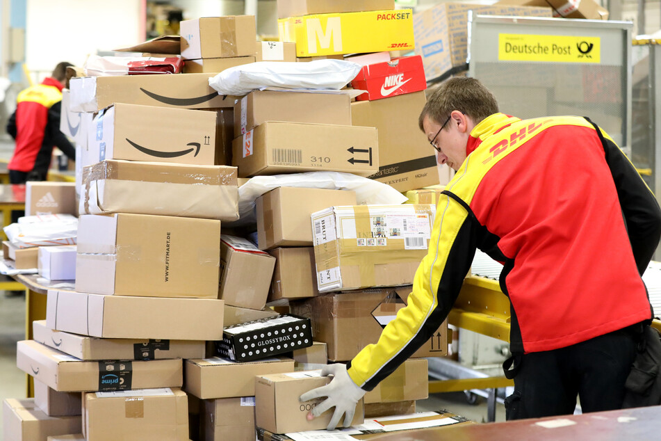 Ein Paketmitarbeiter von DHL und Deutsche Post.