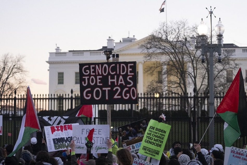 Pro-Palestine activists raise a sign reading "Genocide Joe Has Got 2 Go" in front of the White House in Washington DC.