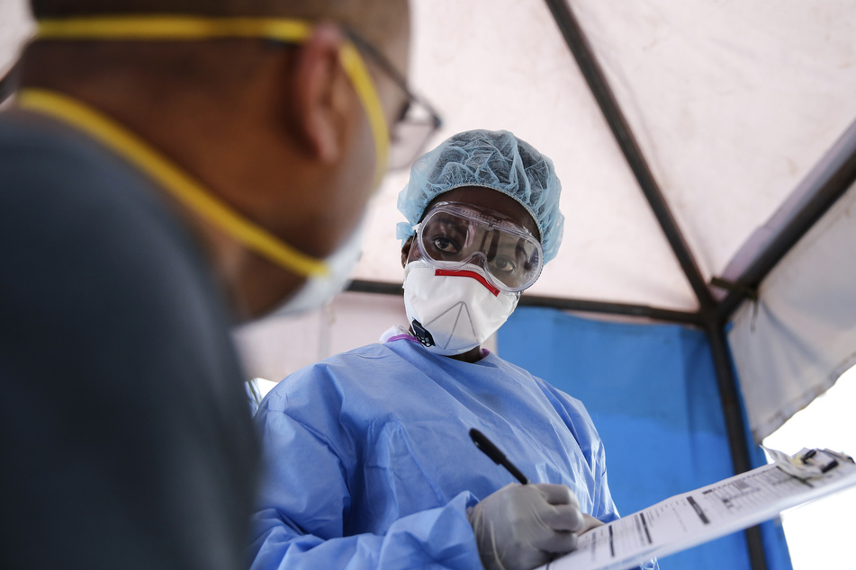 Irene Ooko, Labortechnikerin aus Nairobi, betreut einen Patienten, der auf das Coronavirus getestet werden soll.
