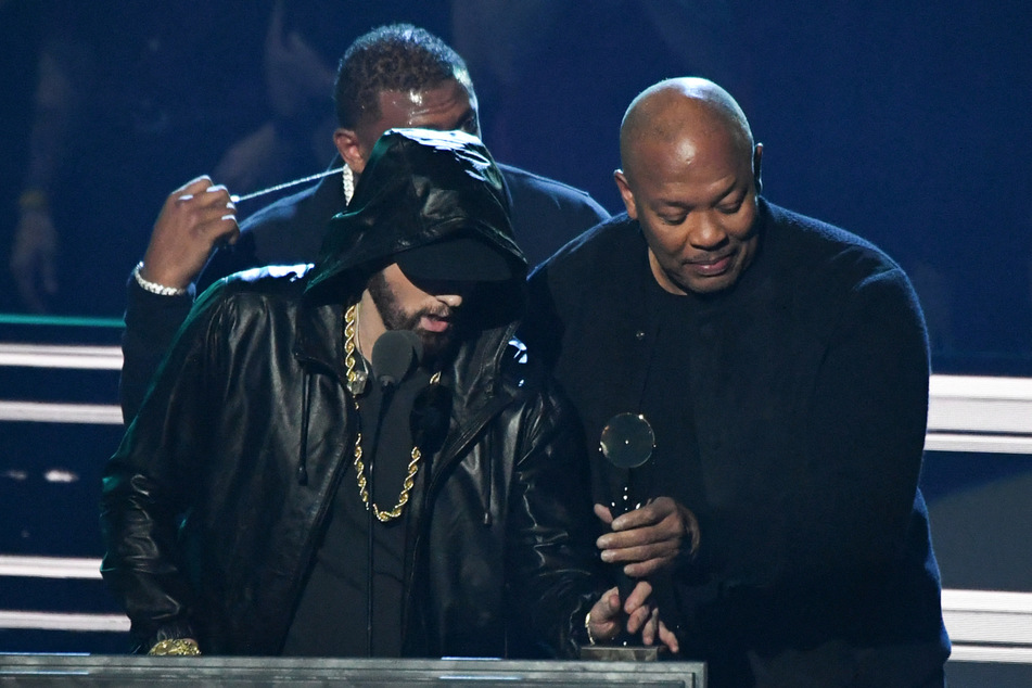 Rapper Dr. Dre giving inductee Eminem (l.) his award during the 37th Annual Rock and Roll Hall of Fame Induction Ceremony in November.