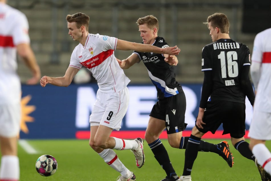 VfB-Stürmer Sasa Kalajdzic (l.) wird von Bielefelds Joakim Nilsson (Mitte) verfolgt.