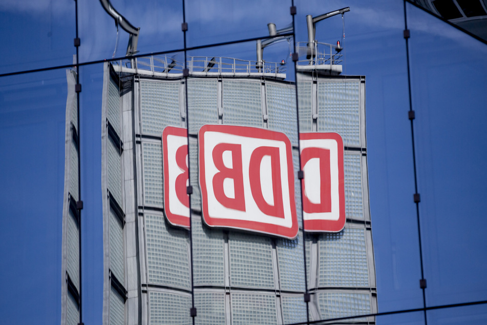 Das Logo der Deutschen Bahn AG (DB) am Berliner Hauptbahnhof spiegelt sich in einer Gebäudefassade.