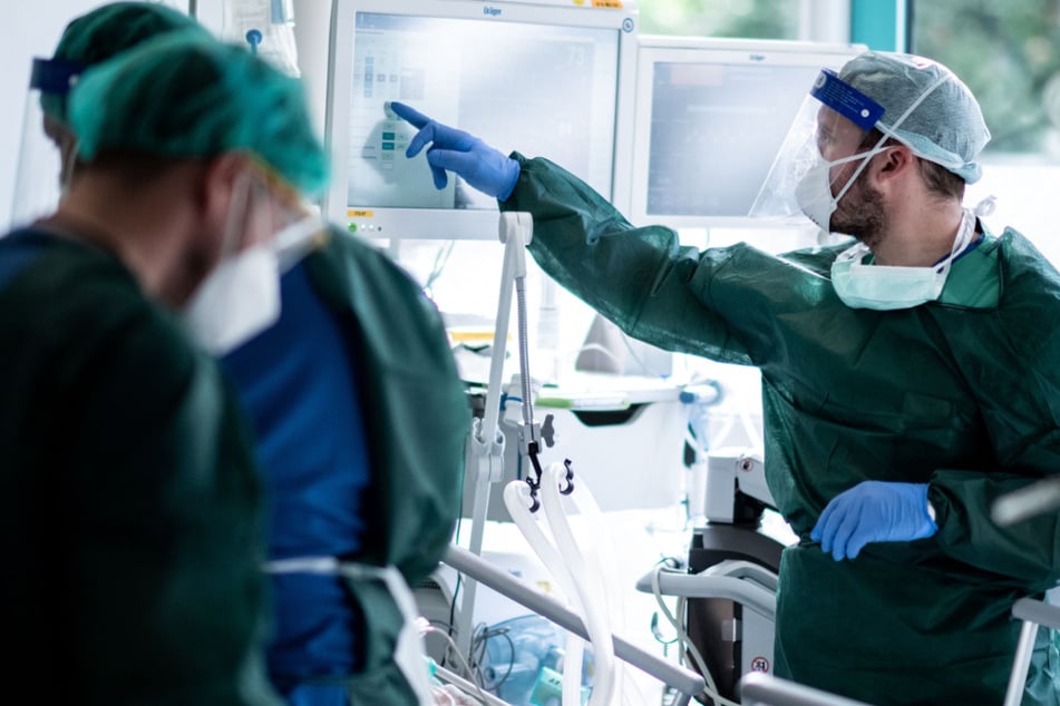 Nordrhein-Westfalen, Essen: Mitarbeiter der Pflege in Schutzkleidung behandeln einen Patienten mit Corona-Infektion auf der Intensivstation IT2 im Operativen Zentrum II des Universitätsklinikums Essen.