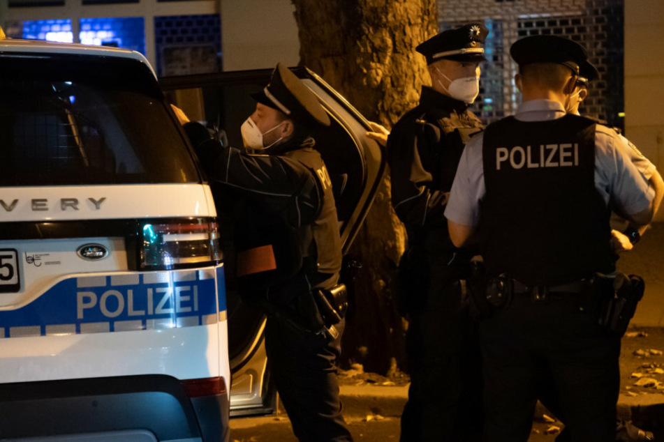 Polizisten stehen bei einer nächtlichen Kontrolle an einem Einsatzfahrzeug in Berlin. (Symbolbild)