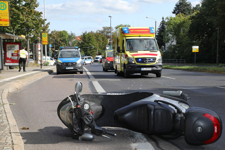 Das Moped liegt auf der Straße, Polizei und Krankenwagen sind im Einsatz.