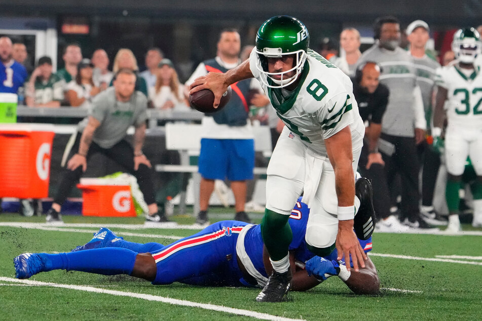 New York Jets quarterback Aaron Rodgers (c.) promised to "rise yet again" after suffering a season-ending injury against the Buffalo Bills.