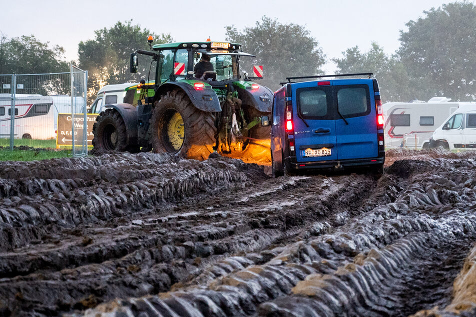 Autos wurden mithilfe eines Traktors auf das Gelände des Heavy-Metal-Festivals in Wacken durch den Schlamm gezogen. Inzwischen wurde dies allerdings gestoppt.