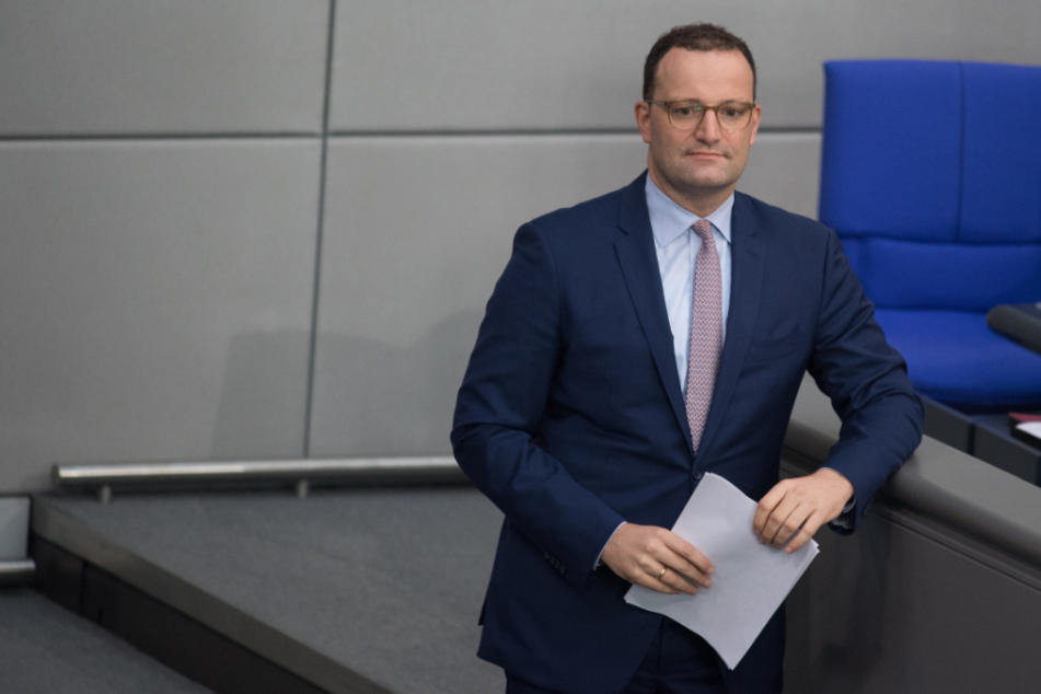 Berlin: Bundesgesundheitsminister Jens Spahn (CDU) steht im Deutschen Bundestag mit einem Manuskript in der Hand und verfolgt eine Debatte.