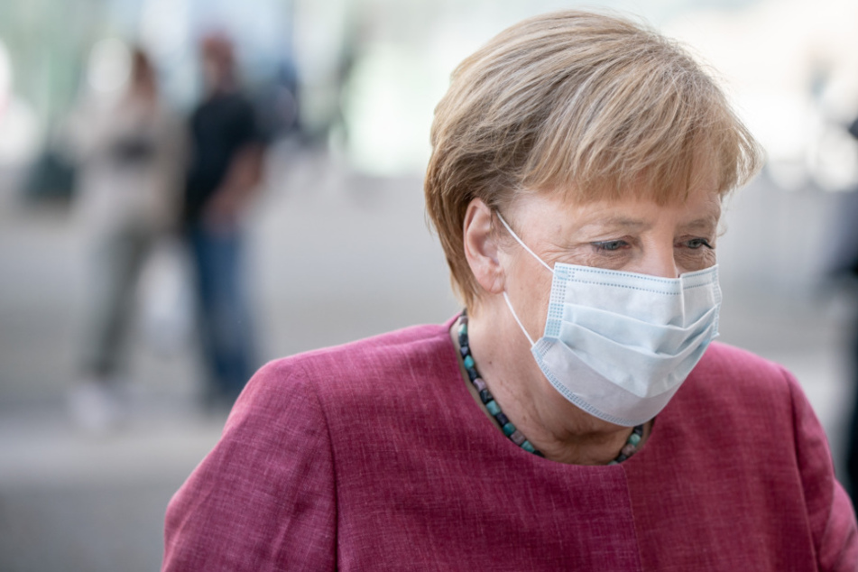 Bundeskanzlerin Angela Merkel (CDU) kommt mit Mund-Nasen-Schutz zur Sitzung der CDU/CSU-Bundestagsfraktion am Bundestag an.