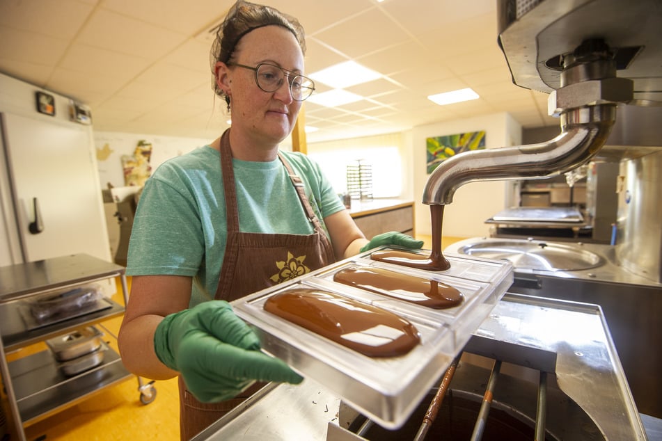 Nicole Knop (39) befüllt eine Tafelform mit flüssiger Schokolade.
