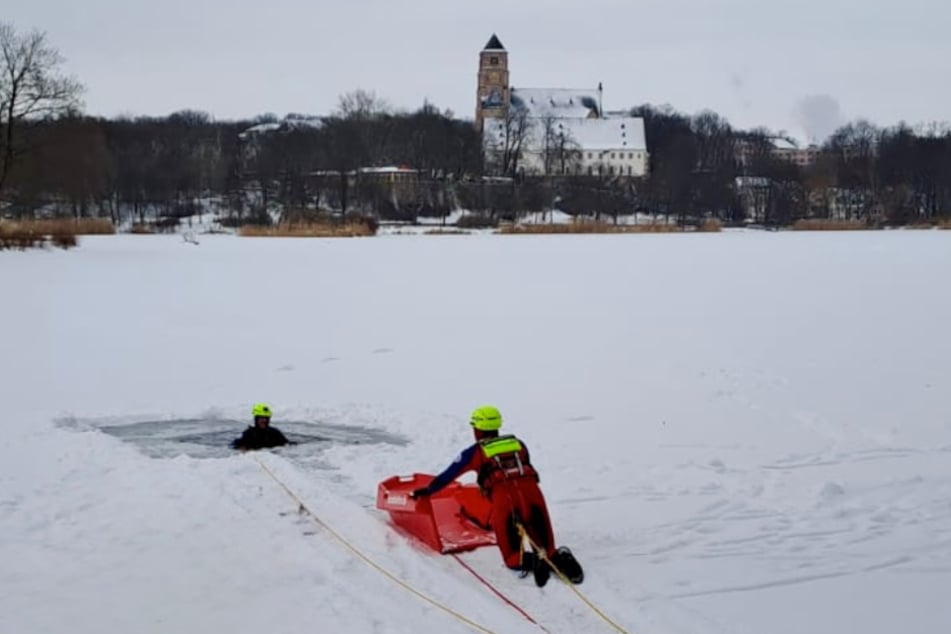 Rettung aus dem Eis: Mit Kombiretter und Sicherungsleinen holen Einsatzkräfte der Wasserwacht eine verunglückte Person kontrolliert aus der eisigen Öffnung - jeder Handgriff sitzt.