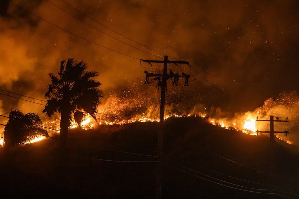 A wildfire burning through Malibu that has sent thousands of people fleeing for safety, including Hollywood celebrities, forged west on Wednesday.