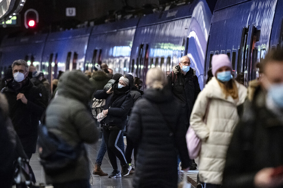 Passagiere mit Mund-Nasen-Schutz gehen durch eine U-Bahn-Station in Malmö.