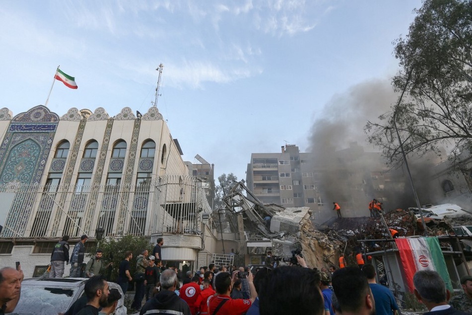 Emergency and security personnel search the rubble at the site of strikes which hit a building annexed to the Iranian embassy in Syria's capital Damascus, on April 1, 2024.