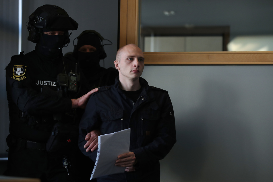Der angeklagte Stephan Balliet wird in Handschellen zu Beginn des elften Prozesstages in den Saal geführt.