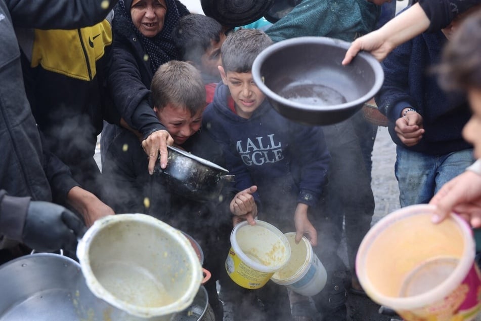 Palestinians queue to receive a food ration outside a distribution center west of Gaza City.