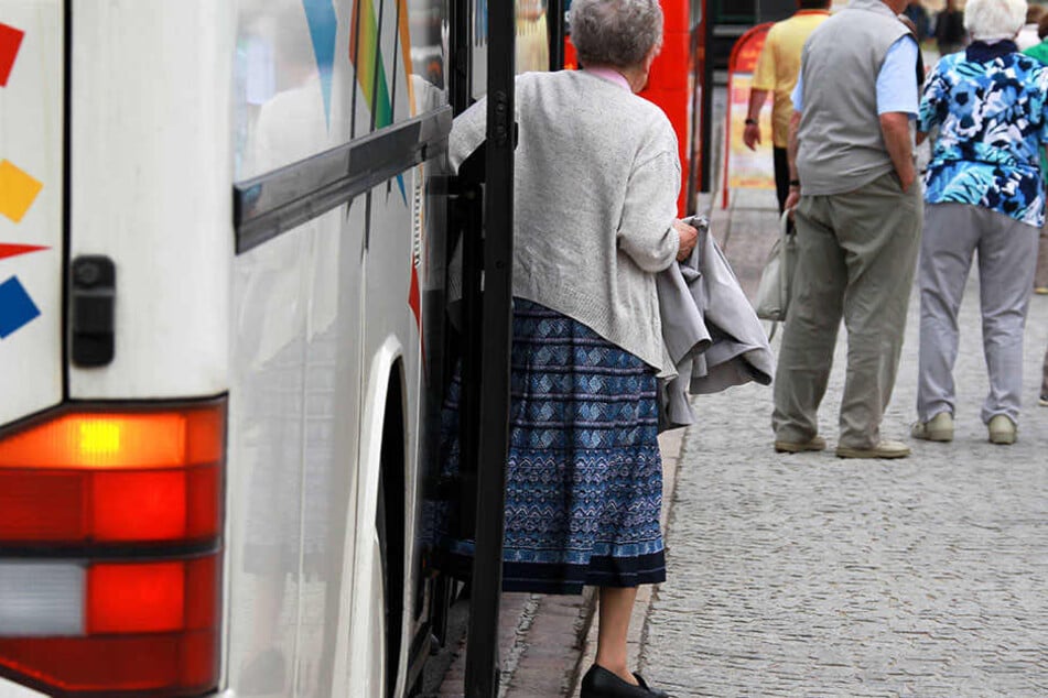 Eine ältere Frau steigt aus einem Reisebus. (Symbolbild)