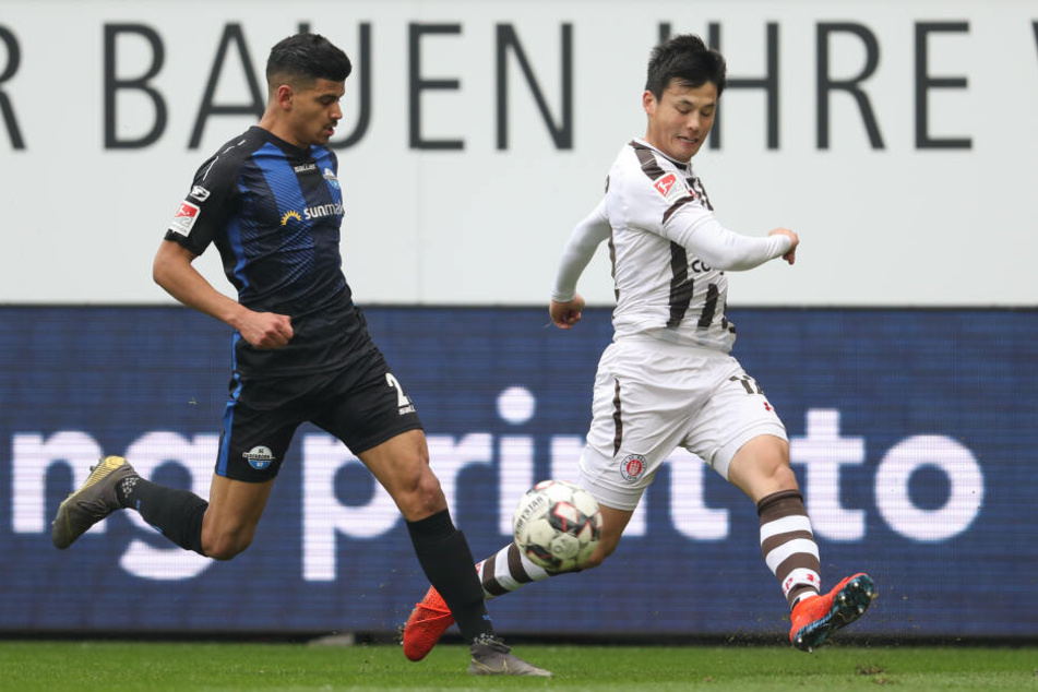 Paderborns Mohamed Dräger (links, SC Paderborn 07) im Kampf um den Ball mit Ryo Miyaichi aus Hamburg.