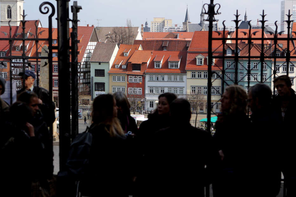 Eine Stadtführerin mit Touristen in Erfurt.