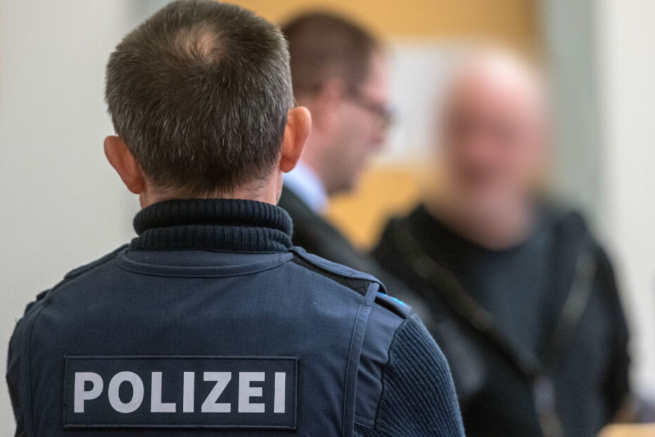 Der 51 Jahre alte Mann (im Hintergrund mit seinem Anwalt) soll in Straubing mit seinem Auto auf zwei auf der Straße stehende Polizisten zugerast sein, um einer Verkehrskontrolle zu entgehen.