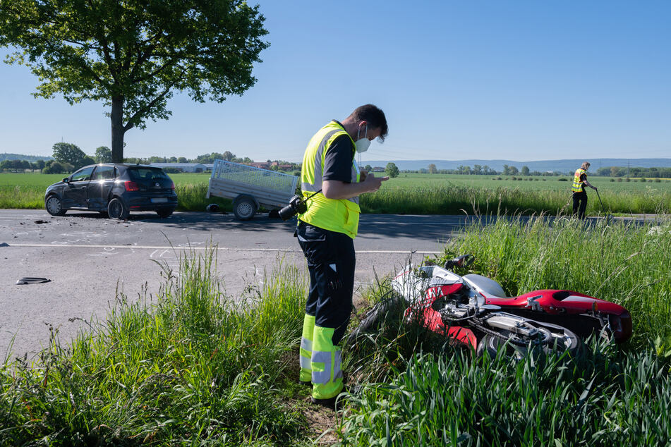 Ein Mitarbeiter der Verkehrsunfallforschung der Medizinischen Hochschule Hannover MHH steht neben dem verunfallten Motorrad an der Kreisstraße bei Groß Munzel.
