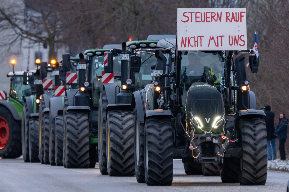 In Stralsund fahren Traktoren vor der Rügenbrücke im Rahmen der Protestwoche der Bauern.
