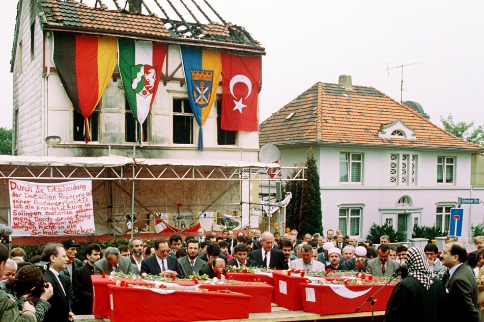03.06.1993, Nordrhein-Westfalen: Das Foto zeigt die Särge von fünf Türkinnen vor dem ausgebrannten Haus in Solingen.
