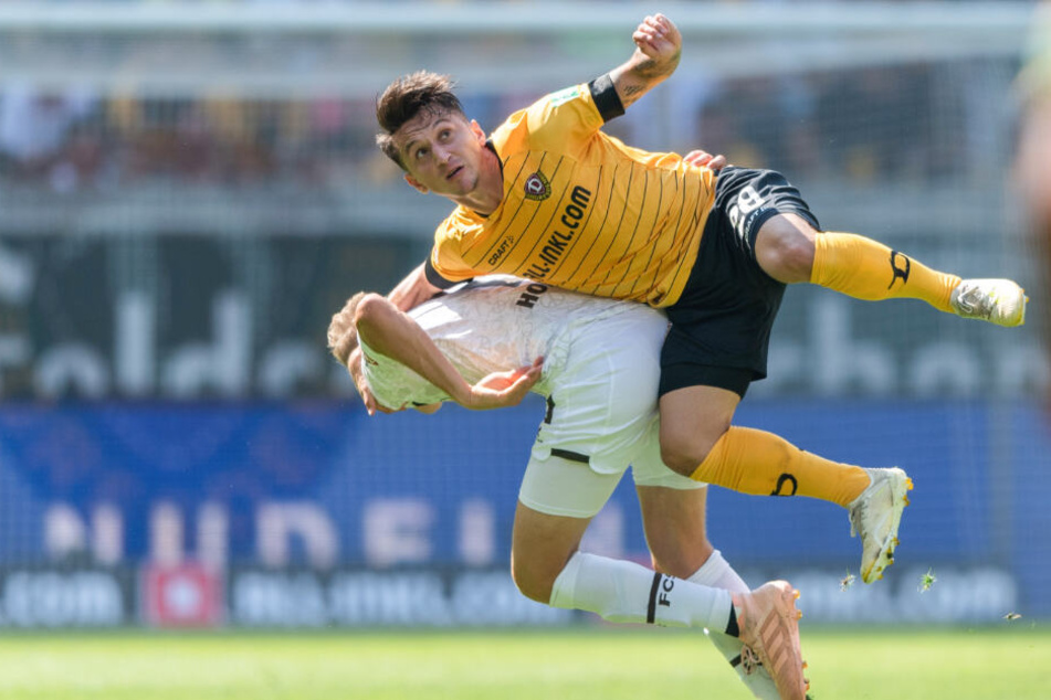 St. Paulis Niklas Hoffmann kämpft mit Dynamos Baris Atik um einen Kopfball.