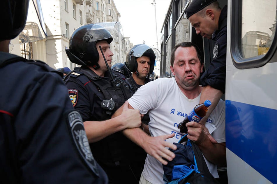 Polizeibeamte verhaften einen Mann, der bei der nicht genehmigten Kundgebung protestierte.