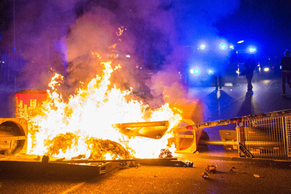 Polizisten stehen im Juli 2017 hinter einer brennenden Barrikade in Hamburg.
