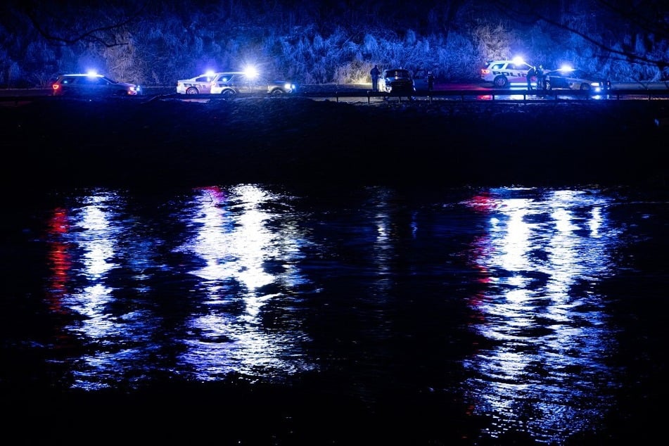 Law enforcement officers surround a vehicle that fell from a cliff near the North Fork Kentucky River amid severe storms on February 16, 2025.