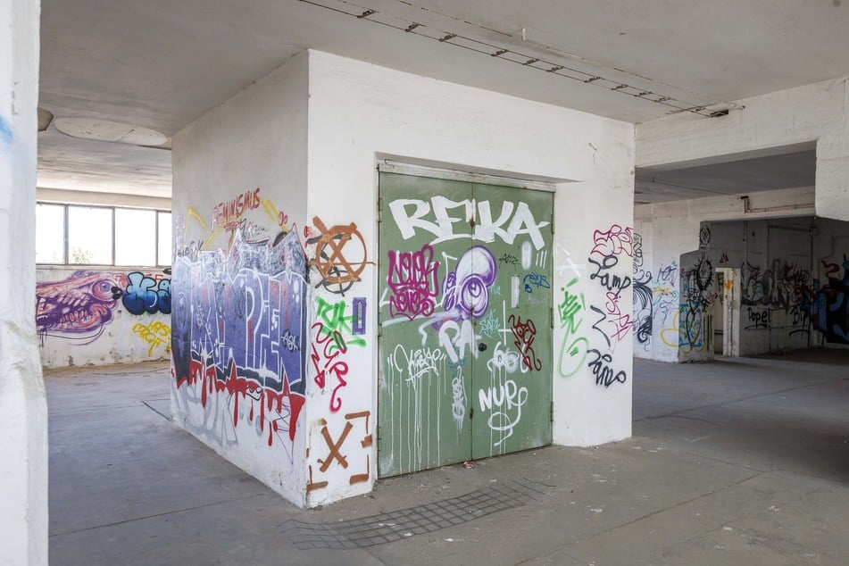 Bunte Graffiti an den Wänden und auf einer grünen Tür, die früher zum Schwerlast-Aufzug führte.