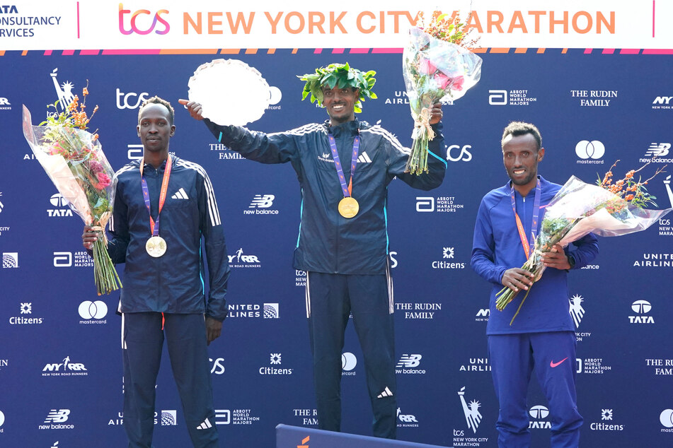 Ethiopia's Tamirat Tola (c) won the men's race of the 2023 New York Marathon with a record-setting time of 2:04:58.