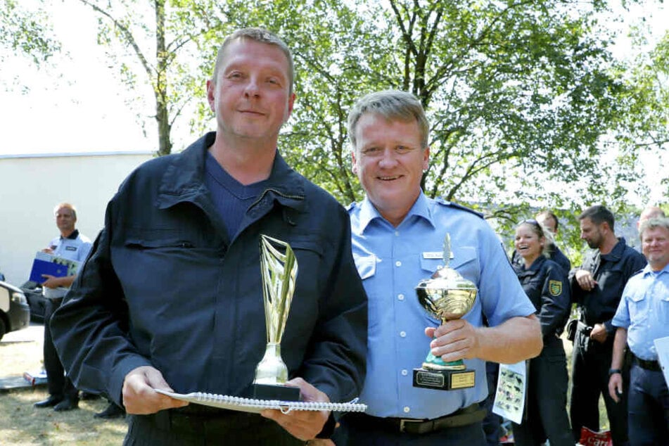 Polizeihauptmeister Dirk Busch erhält vom leitenden Polizeidirektor Jörg Kubiessa den Wanderpokal der Polizeidirektorin für die beste Mannschaft.